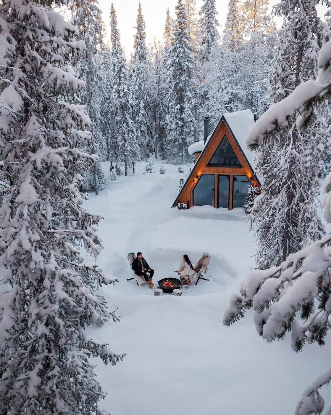 A snow-covered wilderness cabin in Finnish Lapland at dusk